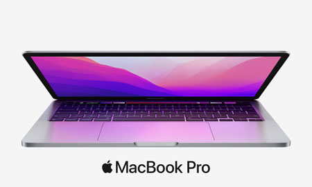 stříbrný polozavřený MacBook M2 s růžovou tapetou